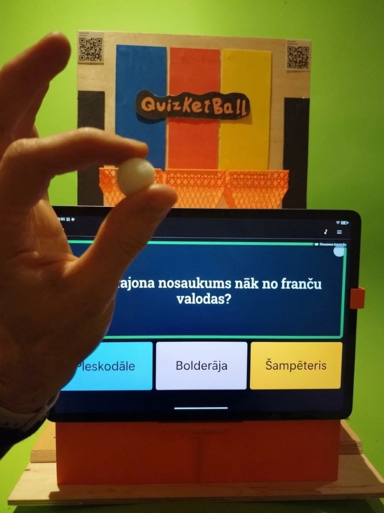 A tablet showing a quiz question, in front of three coloured baskets